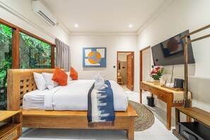 A bedroom with a bed, a desk, a television, and a large window. - Elegant New 2BR in a Complex w Spa, 2 Pools+Garden (Ubud)