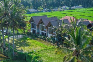 A resort with multiple bungalow-style buildings, surrounded by lush green rice fields and palm trees. - Brand NEW 1BR Villa+Huge Pool+Jungle View+Top Spot (Gianyar Regency)