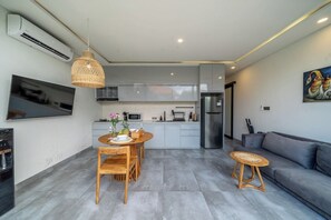Una cocina moderna con zona de comedor, un sofá y una televisión.