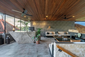 A modern hotel lobby with a reception desk, seating area, and a view of the outside.