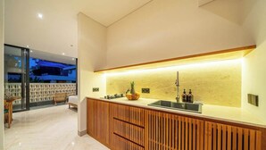 A modern kitchen with a wooden island, a built-in sink, and a view of the outdoors. - Cozy 1BR in Serene Ubud - Kitchen, Balcony, Pool (Gianyar Regency)