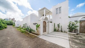 Eine Villa mit gepflasterter Auffahrt, einem hölzernen Tor und einem Schild mit der Aufschrift 'CASA SUD VILLA'.