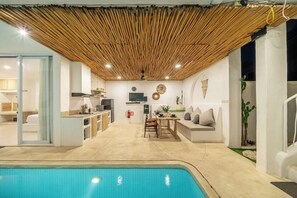 A modern interior with a pool, a dining area, and a living space. - Casa Sud Villa - Modern 3BR w Pool, Outdoor Lounge & Beach Access (Kabupaten Badung)