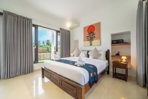 A hotel room with a large bed, a nightstand, a wall-mounted air conditioner, and a view of the outdoors. - New 2BR Villa in Modern Ubud Complex w Spa+2 Pools (Ubud)
