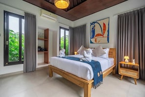 A bedroom with a bed, a nightstand, a shelf, and a painting. - New 2BR Villa in Modern Ubud Complex w Spa+2 Pools (Ubud)