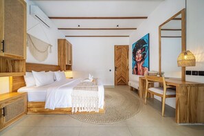 A bedroom with a bed, bedside tables, a desk, a chair, a painting, and a mirror. - Designer 3BR Villa w Garden Bath & Pool • Ubud (Gianyar Regency)