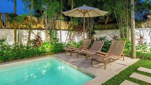 A pool area with lounge chairs and an umbrella. - Designer 3BR Villa w Garden Bath & Pool • Ubud (Gianyar Regency)