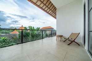 Ein Balkon mit Blick auf Gebäude und Vegetation.