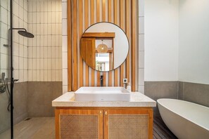A bathroom with a freestanding bathtub, a sink with a wooden vanity, and a shower with a rain showerhead. - Tropical 2BR w Pool • By Canggu's Best Beaches (Kota Denpasar)