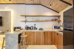 Cocina con encimeras de granito, armarios de madera y microondas integrado.