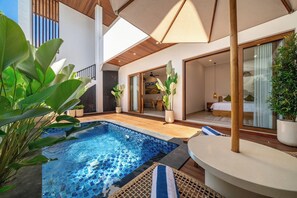 A modern outdoor pool area with a wooden deck, lounge chairs, and potted plants. - Cassandra 3 - Styish 5BR in 500 m to Sanur Beach w Pool+Balcony (Kota Denpasar)