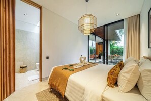 Een moderne slaapkamer met een groot bed, een hanglamp en uitzicht op het groen.