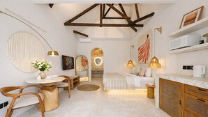 Un interior moderno con zona de comedor, sofá y encimera de cocina.