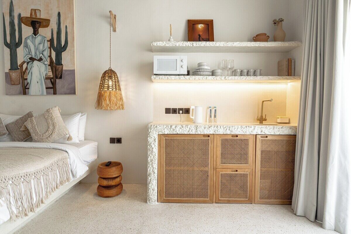 A bedroom with a bed, bedside table, and a wall-mounted painting.