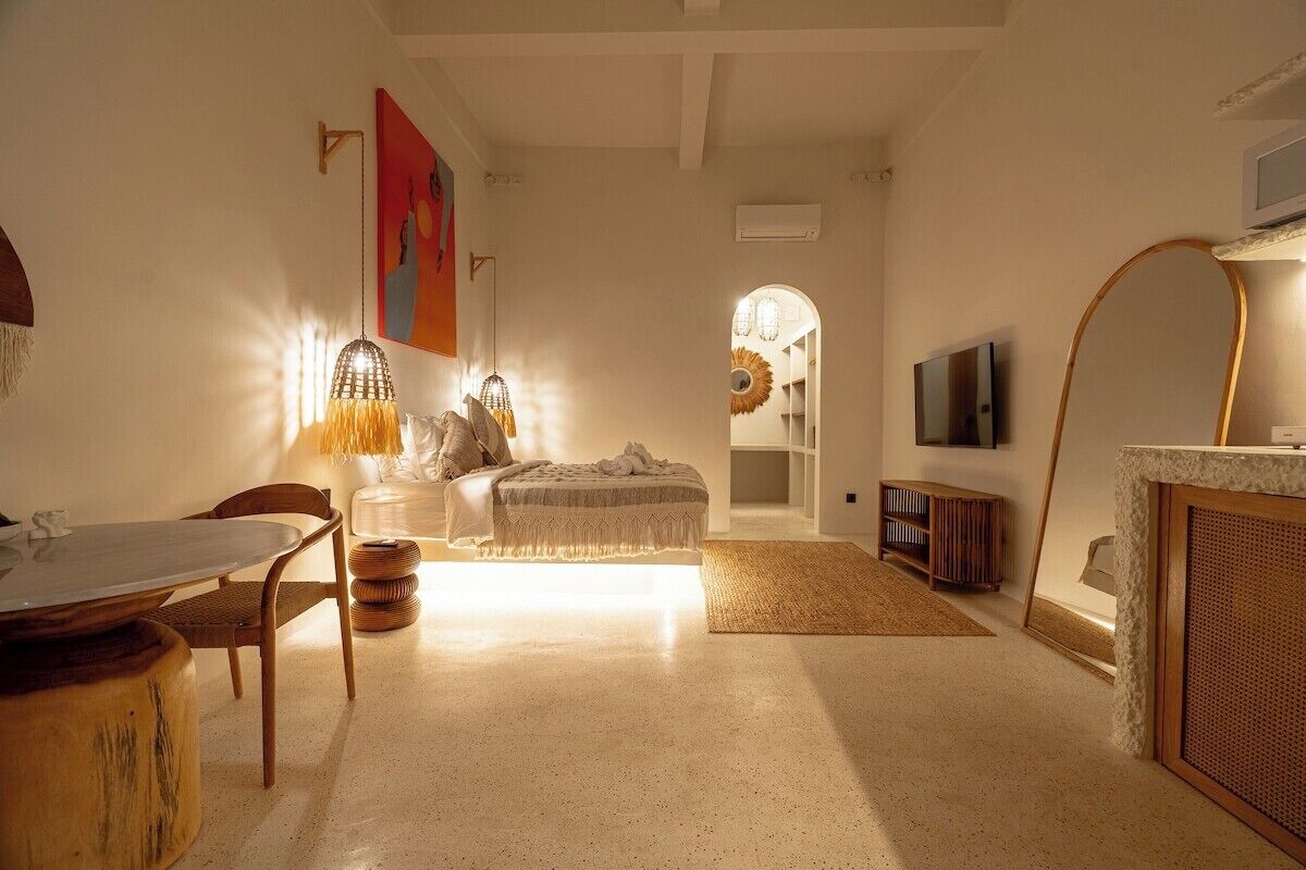 A living room with a dining table, chairs, a sofa, a TV, and a fireplace.