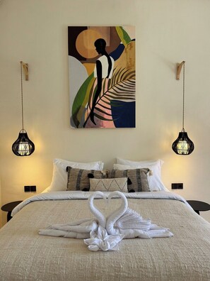 A hotel room with a bed, pillows, a wall art piece, and two hanging light fixtures. - Brand New Apartments in Sanur+500m to Ocean+Pool (Kota Denpasar)