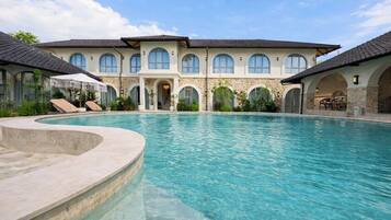 A large swimming pool with a stone facade building in the background.