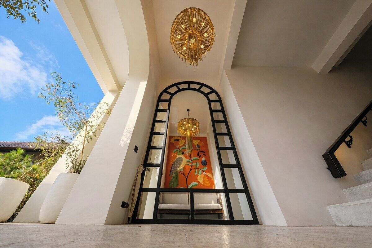 Een modern interieur met een trap die leidt naar een deur met een decoratief schilderij.