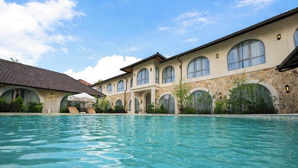 Una piscina con un edificio al fondo.