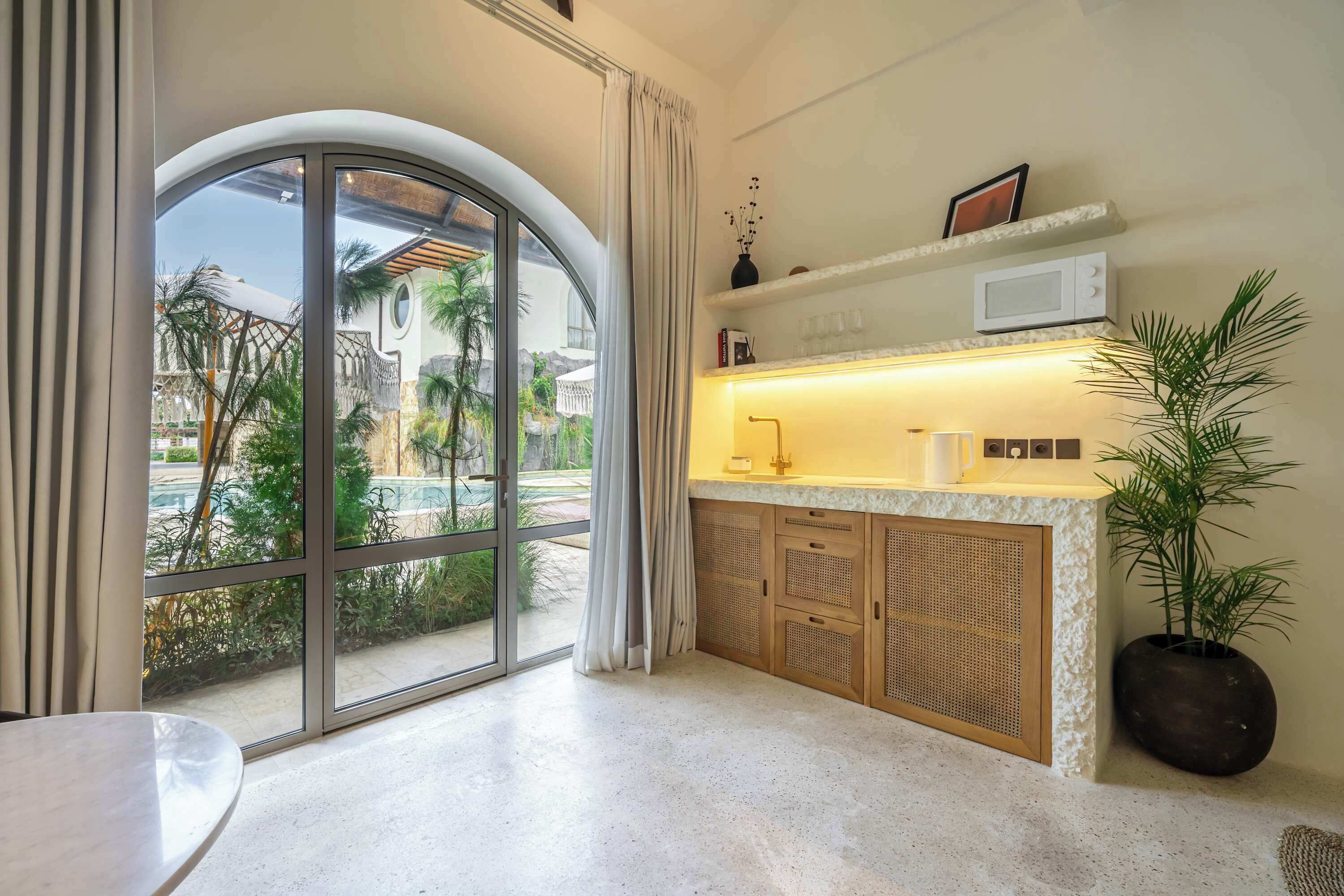 A modern kitchen with a large window, a microwave, and a sink.