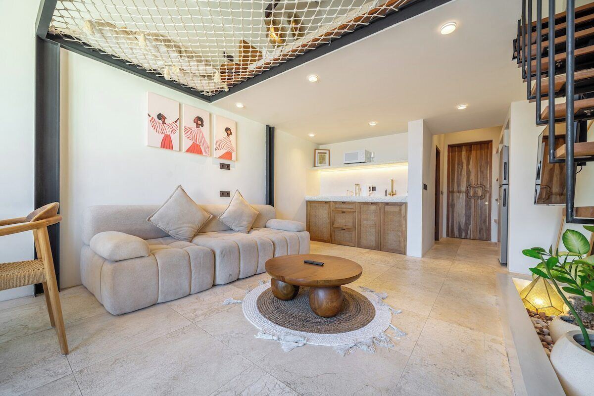 A modern living room with a sofa, coffee table, and artwork on the wall.