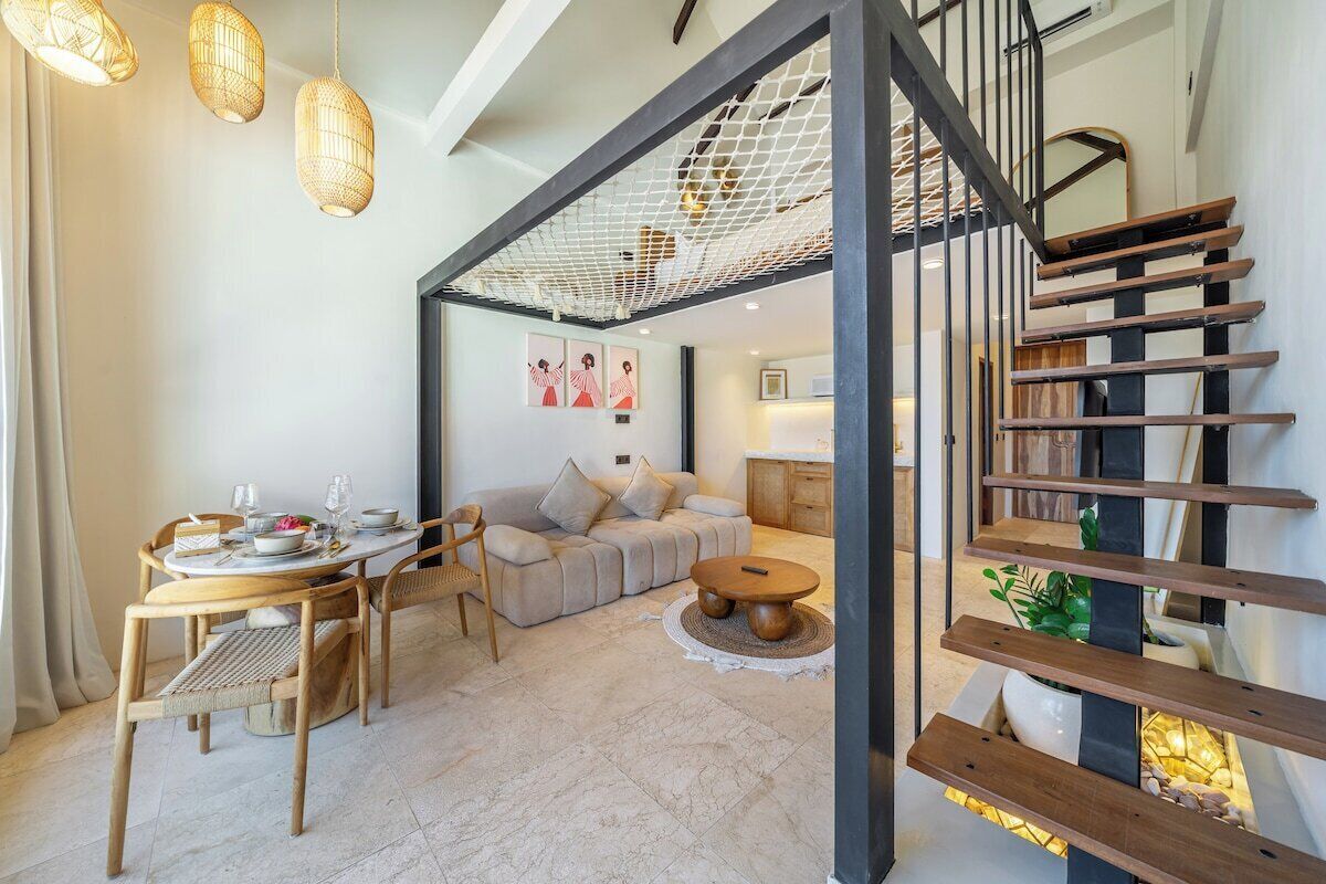 Un interior moderno con una escalera, un comedor y una sala de estar.