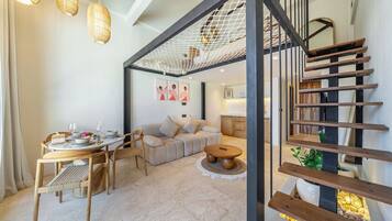 Un interior moderno con una escalera, un comedor y una sala de estar.