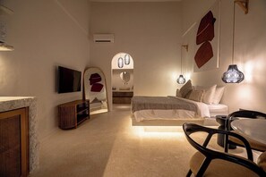 A bedroom with a bed, bedside table, and a TV mounted on the wall. - Modern 1BR in 5 min to Sanur Beach + 2 Pools&Patio (Kota Denpasar)