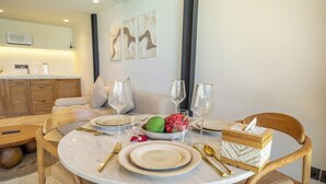 Zona de dinar amb una taula rodona preparada per a quatre, incloent plats, coberts i gots.