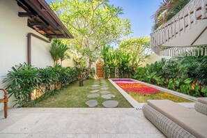 A courtyard with a patterned pathway, lush greenery, and a colorful flower bed. - Chic 2BR Villa by Sanur Beach w Pool +Room Jacuzzi (Kota Denpasar)