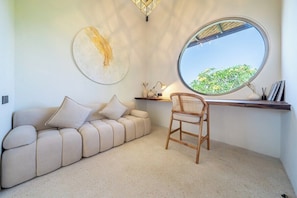 Een modern interieur met een bank, een rond raam en een stoel.