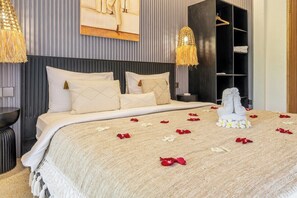 A hotel room with a large bed, a wardrobe, and a painting on the wall. - Cozy 1BR Villa w Patio, Pool & Beach in 5 min Walk (Kota Denpasar)