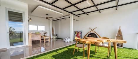 Un interior moderno con comedor, chimenea y vistas al exterior.
