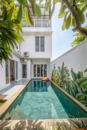 A modern house with a swimming pool, a balcony, and lush greenery. - Chic 3BR in Nusa Dua w Ocean View+Cinema+Rooftop (Kabupaten Badung)