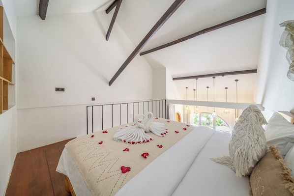 Une chambre avec un lit, un balcon et une vue sur la verdure.