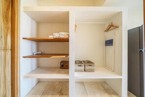 Una cocina moderna con estantes de madera, un perchero para toallas y electrodomésticos integrados.