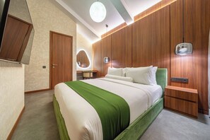 A modern hotel room with a large bed, wooden paneling, a vanity with a mirror, and a small desk. - U Vulla 12 - Modern 2BR Villa w Beach Nearby & Private Pool (Badung Regency)