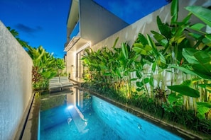 Une piscine intérieure offrant une vue dégagée sur l’architecture environnante et un escalier menant à un niveau supérieur.