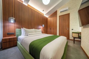 A hotel room with a bed, bedside table, and a small desk with a chair. - U Vulla 12 - Modern 2BR Villa w Beach Nearby & Private Pool (Badung Regency)