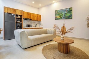 A modern kitchen with wooden cabinets, a refrigerator, and a marble countertop. - Designer 3BR Villa by Sanur Beach • Pool & Rooftop (Denpasar Selatan)