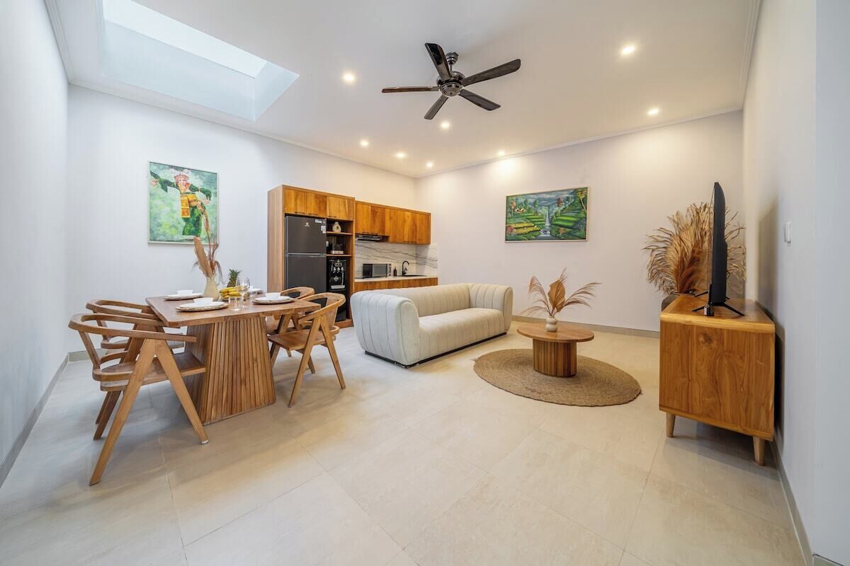 Ein modernes Interieur mit Essbereich, Sofa und Deckenventilator.