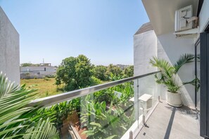 Ein Balkon mit Blick auf eine grüne Landschaft und einen klaren Himmel.