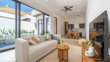 A modern living room with a sofa, coffee table, and a Buddha statue.