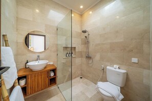 A modern bathroom with a glass-enclosed shower, a wooden vanity, and a toilet. - Chic 3BR Villa 300m to Sanur Beach • Pool & Patio (Kota Denpasar)