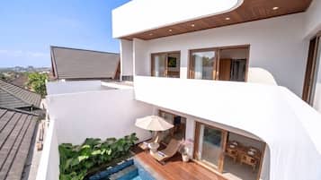 Ein modernes Wohngebäude mit Pool auf dem Dach, einem Balkon mit Sitzgelegenheit und Blick auf die Umgebung.