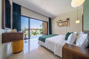 A hotel room with a large bed, a bedside table, a view of the outdoors, and a painting on the wall. - Spacious 2BR Villa w Pool, Garden & Balcony • Ubud (Kabupaten Gianyar)
