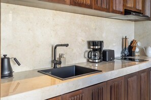 A kitchen with a modern design, featuring a stainless steel sink, a coffee maker, and wooden cabinets. - Spacious 2BR Villa w Pool, Garden & Balcony • Ubud (Kabupaten Gianyar)