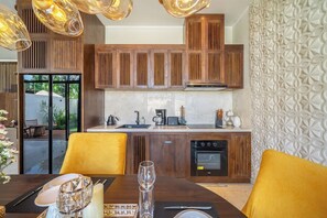 Eine moderne Küche mit Holzausbau, einem eingebauten Backofen und einem Essbereich mit gelben Stühlen.