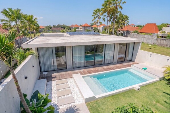 A modern house with a swimming pool, solar panels, and a view of neighboring houses. - Tropical 2BR Villa in Canggu • Beach Nearby • Pool (Kabupaten Tabanan)