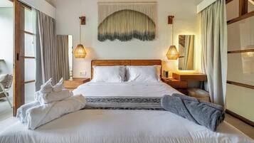 A hotel room with a large bed, two bedside lamps, a wall tapestry, and a mirror.